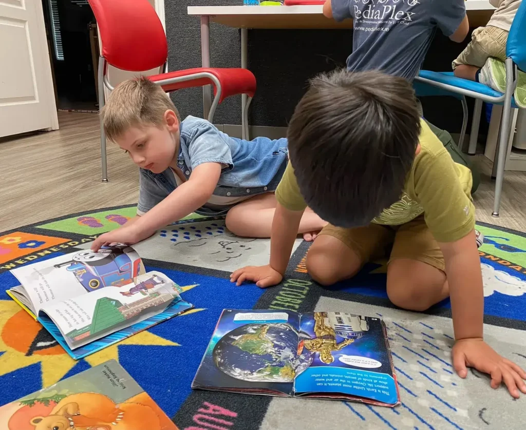 Two kids playing with coloring books at PediaPlex