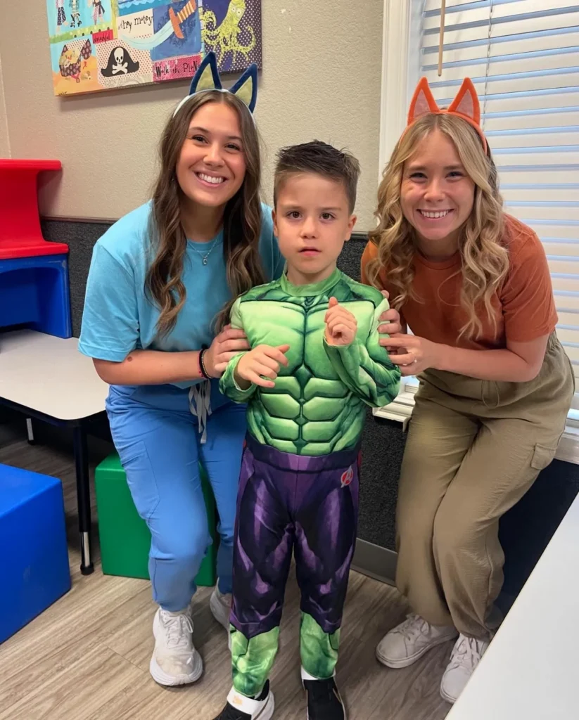 Two PediaPlex staff with a child dressed as the Hulk